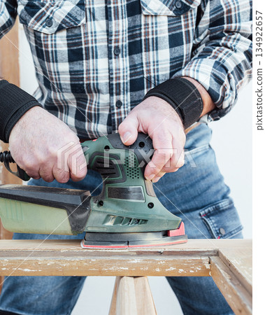 Carpenter at work, restoring an old wooden window. Carpentry. 134922657