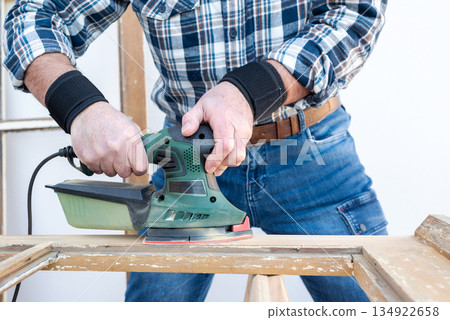 Carpenter at work, restoring an old wooden window. Carpentry. 134922658