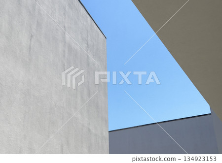 Abstract view of modern white walls with strong angular lines cutting into a clear blue sky. 134923153
