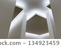 Modern architectural ceiling design with suspended geometric panels and diffused lighting. 134923459