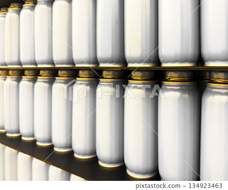 Close-up of shelves filled with white cans, soda jars with golden lids, neatly aligned in multiple Close-up of shelves filled with white cans, soda jars with golden lids, neatly aligned in multiple 134923463