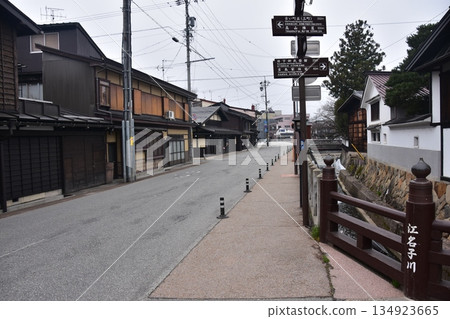 The old townscape of Takayama City, Gifu Prefecture, Japan. Old houses exuding a sense of history. Signs pointing to tourist attractions and a stream running through the city. The old townscape of Takayama City, Gifu Prefecture, Japan. Old houses exuding a sense of history. Signs pointing to tourist attractions and a stream running through the city. 134923665