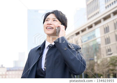 A man using a smartphone in an office district A man using a smartphone in an office district 134923955