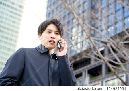 一名男子在辦公區使用智慧型手機 134923964