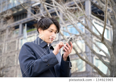 一名男子在辦公區使用智慧型手機 134923965