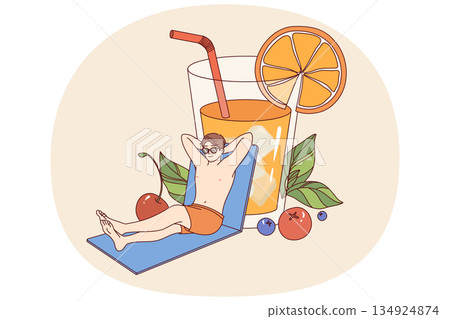 Man relaxed on beach and drinks orange juice from giant glass, enjoying sunny weather Man relaxed on beach and drinks orange juice from giant glass, enjoying sunny weather 134924874