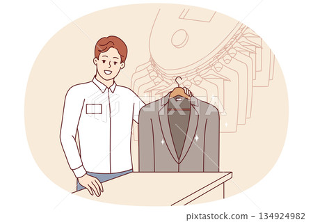 Man working in dry cleaner shows business jacket, cleaned of stains from food or sauce 134924982