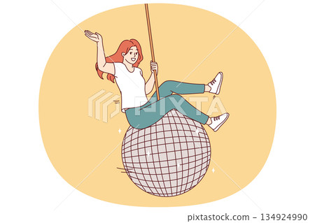 Woman swings on large disco ball and waves hand welcomingly, inviting guests to student party 134924990