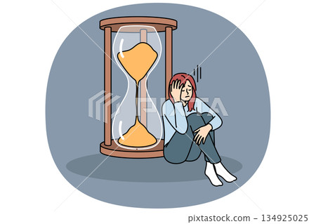 Woman sad about strict deadlines sitting near hourglass, and needs skills to improve productivity. 134925025