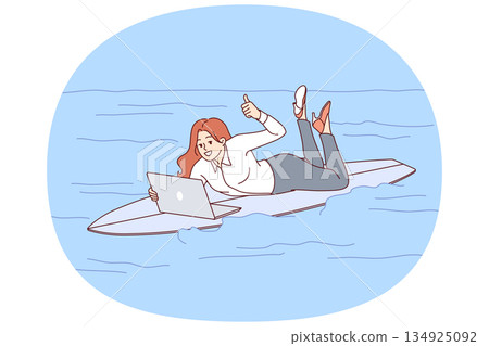 Woman freelancer rides surfboard on sea and works with laptop, showing thumbs up Woman freelancer rides surfboard on sea and works with laptop, showing thumbs up 134925092