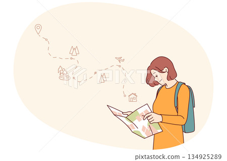Woman tourist uses paper map to travel through nature reserves and plot route to destination 134925289