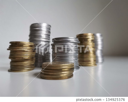 Cooper and silver coin piles on white background 134925376