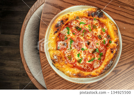 Homemade pepperoni pizza with melted cheese and golden crispy crust served on wooden table, top view 134925500