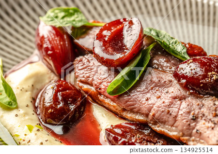 Sliced grilled duck breast fillet with caramelized plums and creamy puree in fine dining style 134925514