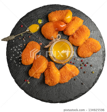 Chicken nuggets with sauce on black slate board isolated on white background 134925596