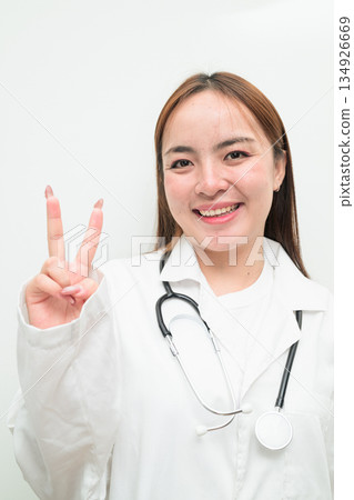 Portrait of young Asian female doctor against white background Portrait of young Asian female doctor against white background 134926669