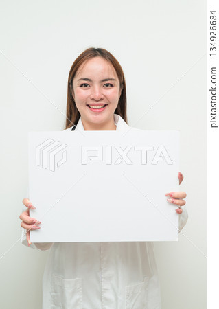 Portrait of young Asian female doctor holding white board with copy space for text 134926684