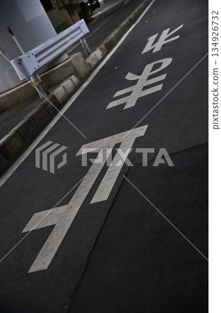 The letters on the stop sign written on the road surface of the japan roadway. Japanese street signs. Translation: Japanese Kanji letter telling car drivers to stop. 134926732