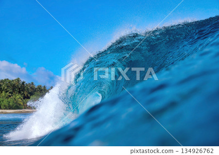 Energetic surf soaring over coral reef with dazzling sunlight reflections 134926762