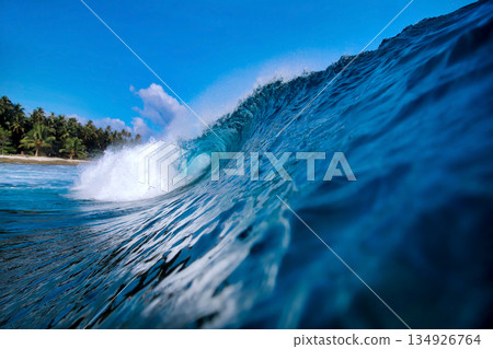 Energetic surf soaring over coral reef with dazzling sunlight reflections 134926764