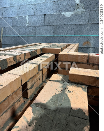 Fresh brickwork of a heating stove ash pit and bench. Smoke channels of the bench are visible. Close-up& Fresh brickwork of a heating stove ash pit and bench. Smoke channels of the bench are visible. Close-up& 134928589