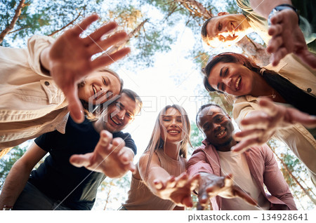 Looking down. View from below of group of friends that are in the forest Looking down. View from below of group of friends that are in the forest 134928641