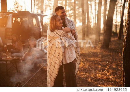 Lovely couple embracing each other, in smoke. Group of friends are together in the forest Lovely couple embracing each other, in smoke. Group of friends are together in the forest 134928655