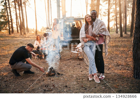 Conception of love, couple embracing each other. Group of friends are together in the forest Conception of love, couple embracing each other. Group of friends are together in the forest 134928666