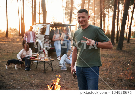 Adult man is standing. Group of friends are together in the forest 134928675