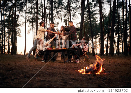Beautiful bonfire at evening time. Group of friends are together in the forest Beautiful bonfire at evening time. Group of friends are together in the forest 134928702