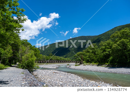 Myojin Bridge and mountains along Kamikochi hiking trail, Japan Myojin Bridge and mountains along Kamikochi hiking trail, Japan 134928774
