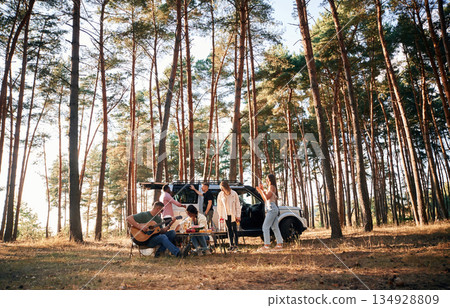 Musician playing guitar. Group of friends are together in the forest 134928809