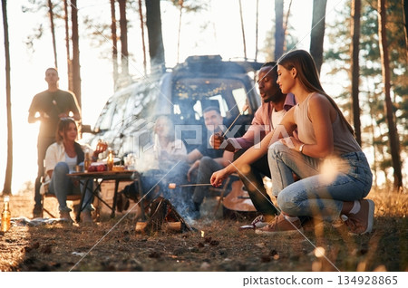 Time for preparing marshmallows on bonfire. Group of friends are together in the forest 134928865