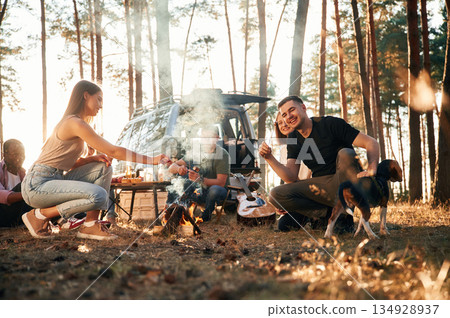 By bonfire. Group of friends are together in the forest 134928937
