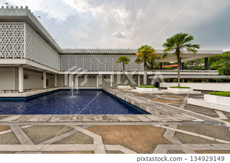 National Mosque, Masjid Negara exterior with modern architecture, fountains, and palm trees in Kuala Lumpur, Malaysia. 134929149