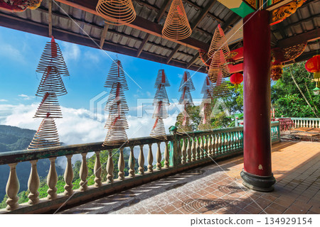 Traditional spiral incense hanging at Chin Swee Caves Temple, Genting Highlands, Pahang, Malaysia, overlooking misty mountains. Traditional spiral incense hanging at Chin Swee Caves Temple, Genting Highlands, Pahang, Malaysia, overlooking misty mountains. 134929154