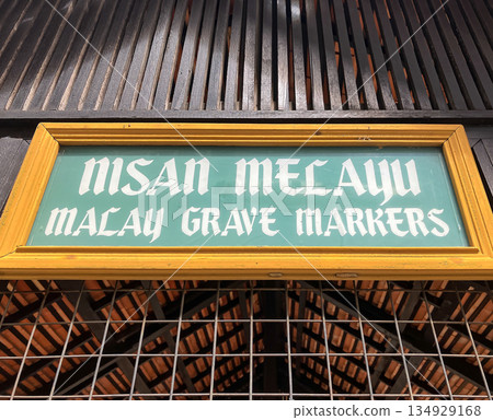 Green sign reading: Nisan Melayu - Malay Grave Markers, on a wooden pavilion at Muzium Negara, Kuala Lumpur, Malaysia Green sign reading: Nisan Melayu - Malay Grave Markers, on a wooden pavilion at Muzium Negara, Kuala Lumpur, Malaysia 134929168