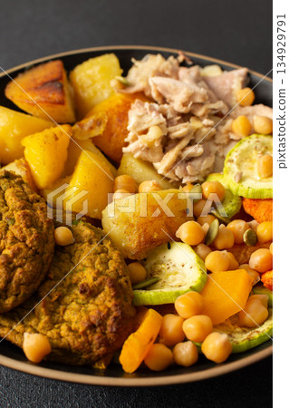 This hearty breakfast showcases a plate filled with baked sweet potatoes, carrots, zucchini, lentil cutlets, chicken breast This hearty breakfast showcases a plate filled with baked sweet potatoes, carrots, zucchini, lentil cutlets, chicken breast 134929791