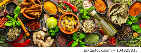 A rich palette of colorful spices and herbs, resting on a brown background, radiating freshness and an inviting aroma, perfect for gourmet inspiration, banner A rich palette of colorful spices and herbs, resting on a brown background, radiating freshness and an inviting aroma, perfect for gourmet inspiration, banner 134929835