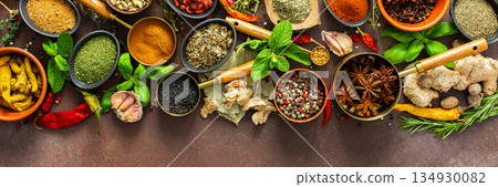 A rich palette of colorful spices and herbs, resting on a brown background, radiating freshness and an inviting aroma, perfect for gourmet inspiration, banner A rich palette of colorful spices and herbs, resting on a brown background, radiating freshness and an inviting aroma, perfect for gourmet inspiration, banner 134930082