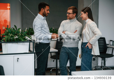 Standing and talking. Couple are in the office, getting consulted by a manager Standing and talking. Couple are in the office, getting consulted by a manager 134930139