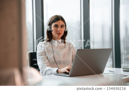 Beautiful young woman is working in the office by laptop 134930216