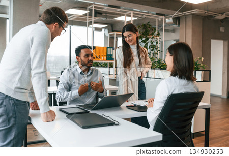 By the table. Four people are working in the office together By the table. Four people are working in the office together 134930253