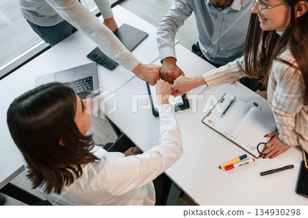 Top view. Four people are working in the office together Top view. Four people are working in the office together 134930298