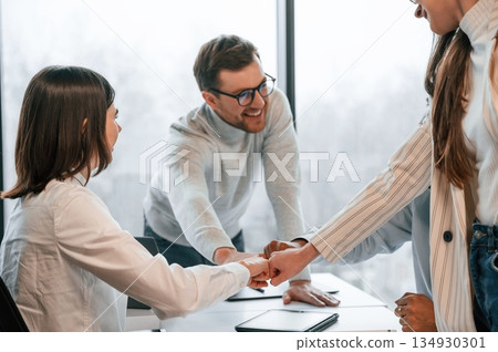 Knocking the fists. Four people are working in the office together Knocking the fists. Four people are working in the office together 134930301