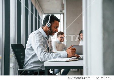 Everyone is using laptop. Men and woman are working in the office together Everyone is using laptop. Men and woman are working in the office together 134930360