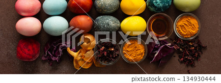 A vibrant assortment of Easter eggs rests on a surface, beautifully dyed in various colors. Natural dye ingredients, such as beets, turmeric and hibiscus, red cabbage and onion peel, vinegar, banner A vibrant assortment of Easter eggs rests on a surface, beautifully dyed in various colors. Natural dye ingredients, such as beets, turmeric and hibiscus, red cabbage and onion peel, vinegar, banner 134930444