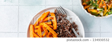 Brown rice paired with baked sweet potatoes creates a hearty, healthy and flavorful dish thats both filling and nutritious, fresh salad of tomatoes cucumbers with herbs 134930532