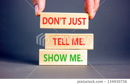 Tell or show symbol. Concept words Do not just tell me, show me on beautiful wooden blocks. Beautiful grey background. Businessman's hand. Business tell or show concept. Copy space. 134930736