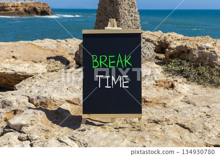Break time symbol. Concept word Break time on beautiful black blackboard. Beautiful stone and blue sea sky background. Black blackboard. Business break time concept. Copy space. Break time symbol. Concept word Break time on beautiful black blackboard. Beautiful stone and blue sea sky background. Black blackboard. Business break time concept. Copy space. 134930780